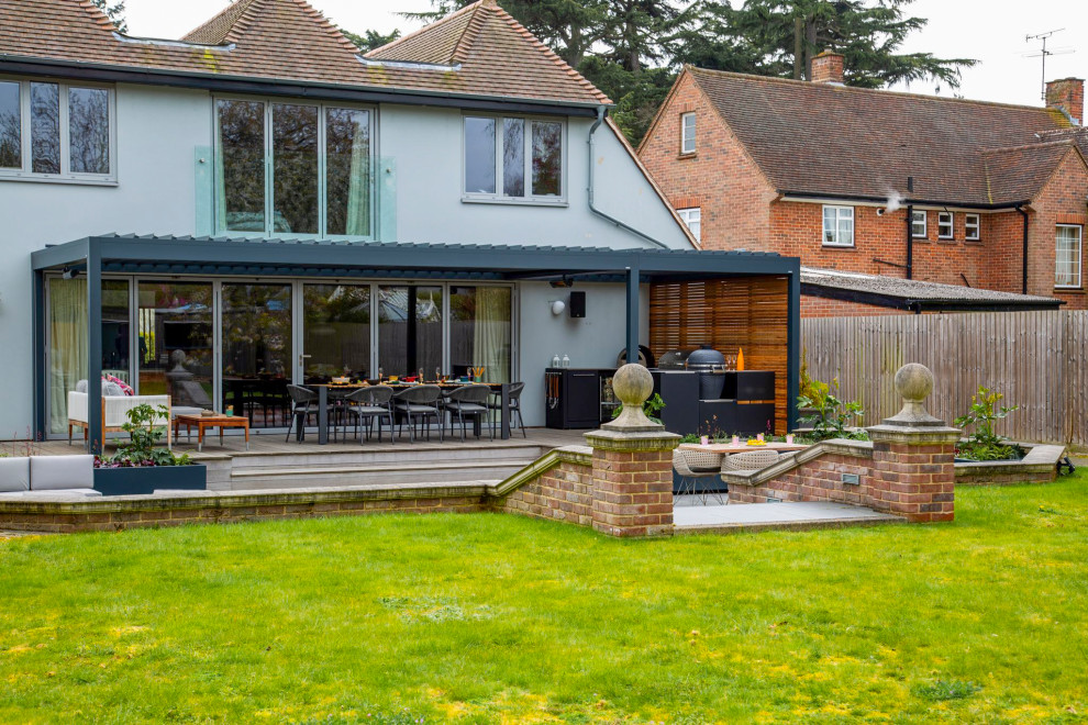 Photo of a medium sized contemporary back patio in Essex with an outdoor kitchen, decking and a pergola.