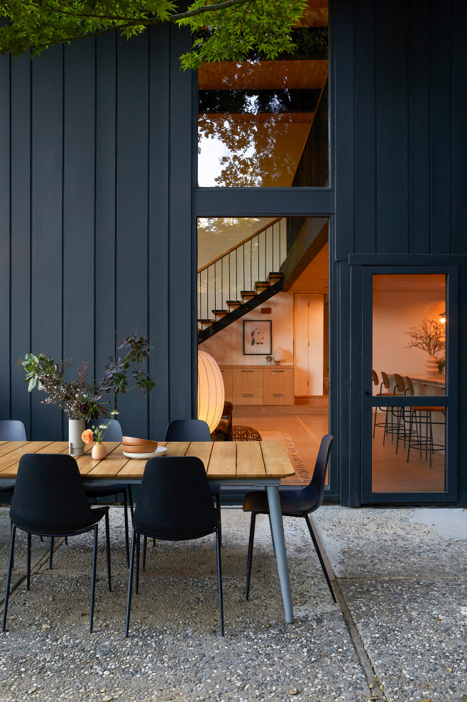 Стильный дизайн: двухэтажный, деревянный, черный частный загородный дом среднего размера в стиле ретро с плоской крышей - последний тренд