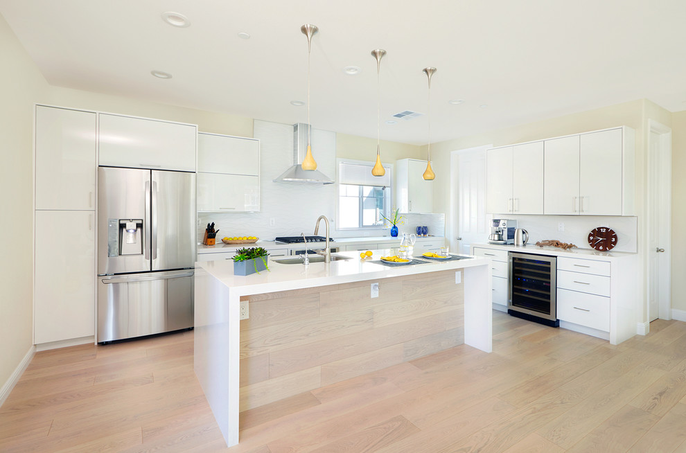 Inspiration for a large contemporary open plan kitchen in San Francisco with a drop-in sink, flat-panel cabinets, white cabinets, white splashback, stainless steel appliances and with island.