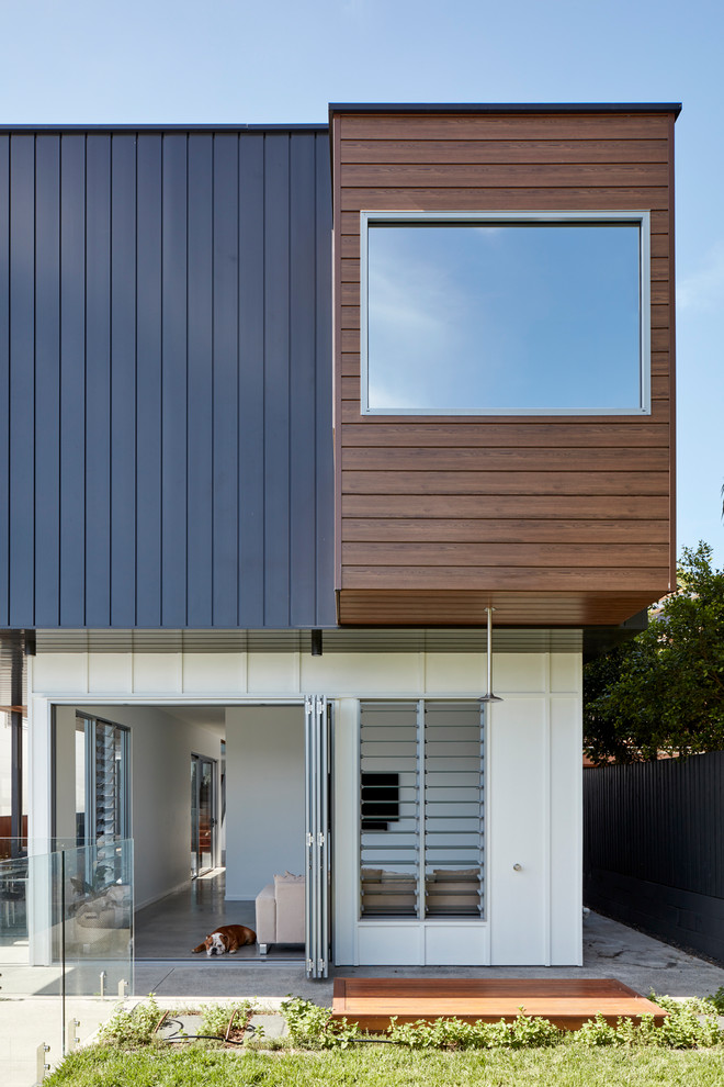 This is an example of a contemporary two-storey multi-coloured house exterior in Brisbane with mixed siding and a flat roof.