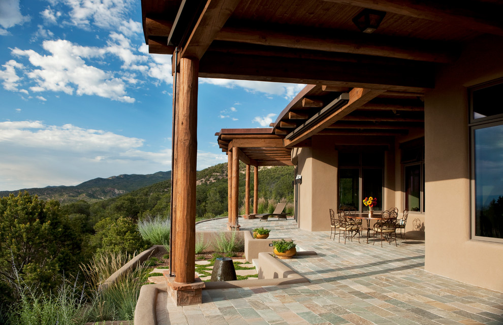 This is an example of a mediterranean patio in Albuquerque with a roof extension.