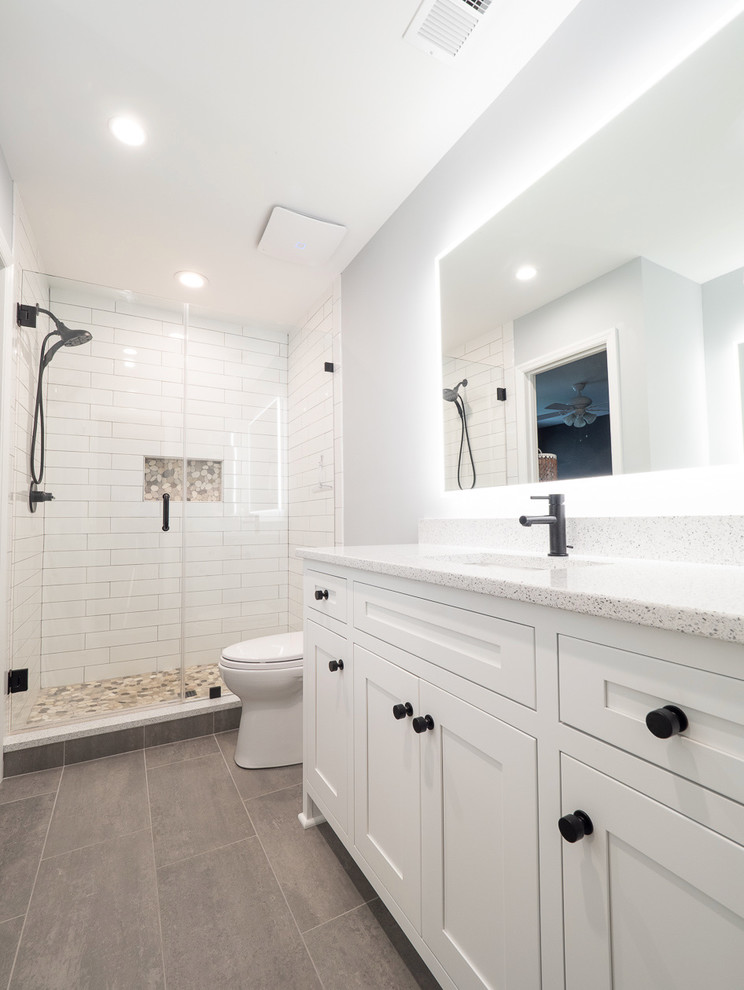 Transitional 3/4 bathroom in Charleston with grey walls, ceramic floors, grey floor, shaker cabinets, white cabinets, an alcove shower, white tile, subway tile, an undermount sink, quartzite benchtops, a hinged shower door and beige benchtops.
