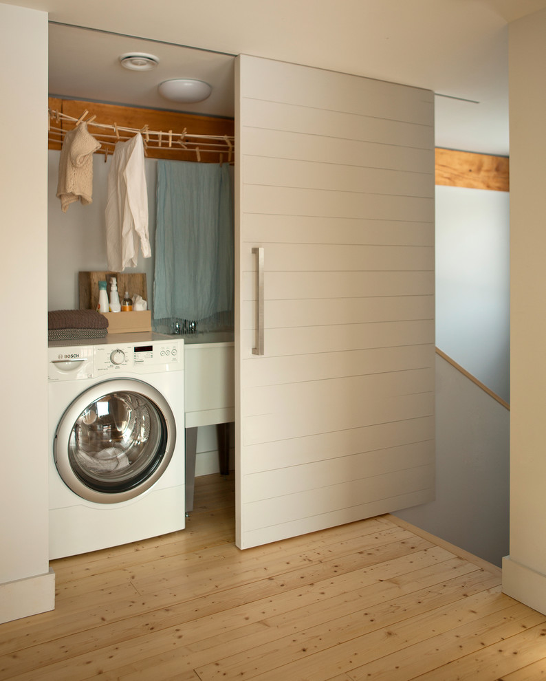 Contemporary laundry room in Portland Maine with white walls.