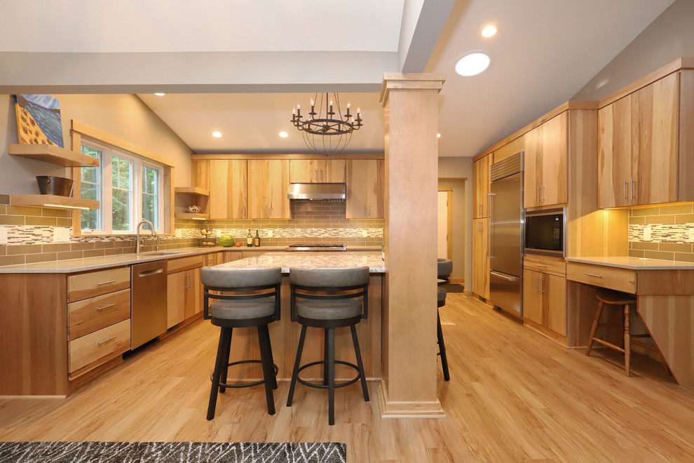Example of a mid-sized transitional u-shaped light wood floor and brown floor eat-in kitchen design in Grand Rapids with an undermount sink, flat-panel cabinets, light wood cabinets, quartz countertops, brown backsplash, ceramic backsplash, stainless steel appliances and an island