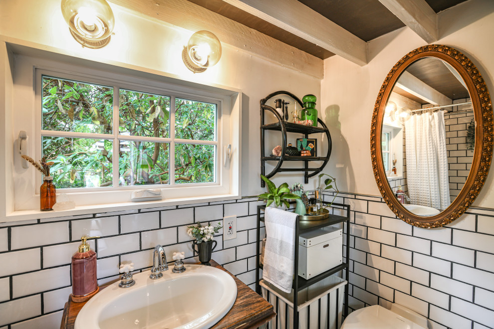 Inspiration for a country bathroom in Portland with dark wood cabinets, a freestanding tub, white tile, subway tile, white walls, dark hardwood floors, a drop-in sink, wood benchtops, brown floor, a shower curtain and brown benchtops.