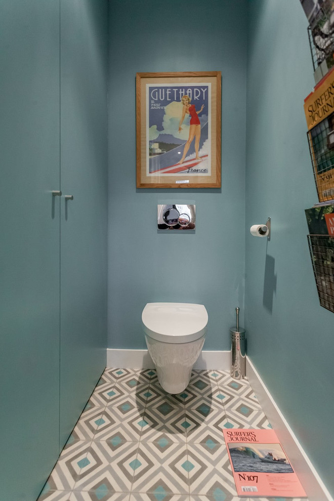 Design ideas for a mid-sized contemporary powder room in Bordeaux with blue cabinets, a wall-mount toilet, blue walls and ceramic floors.