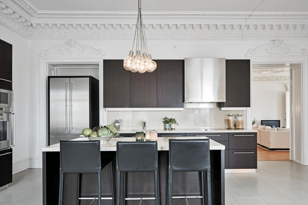 Inspiration for a mid-sized contemporary single-wall eat-in kitchen in Gothenburg with flat-panel cabinets, dark wood cabinets, white splashback, stainless steel appliances, with island, a single-bowl sink, marble benchtops and ceramic floors.
