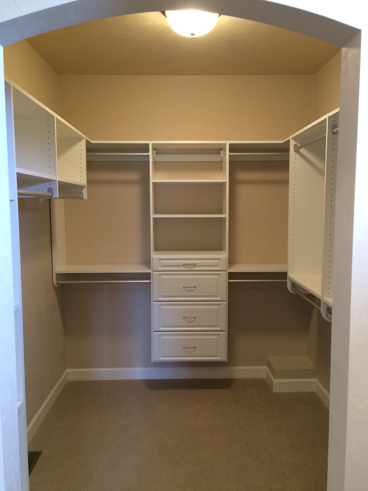 Photo of a mid-sized arts and crafts gender-neutral walk-in wardrobe in Other with raised-panel cabinets, white cabinets and carpet.