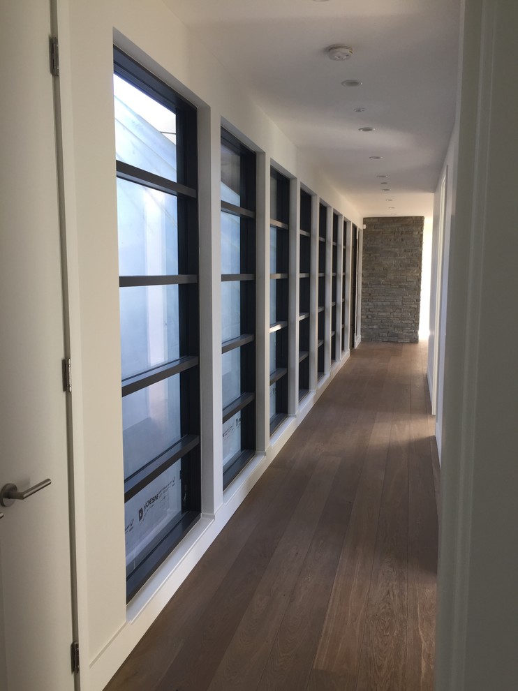 Photo of a mid-sized modern hallway in Phoenix with white walls and dark hardwood floors.