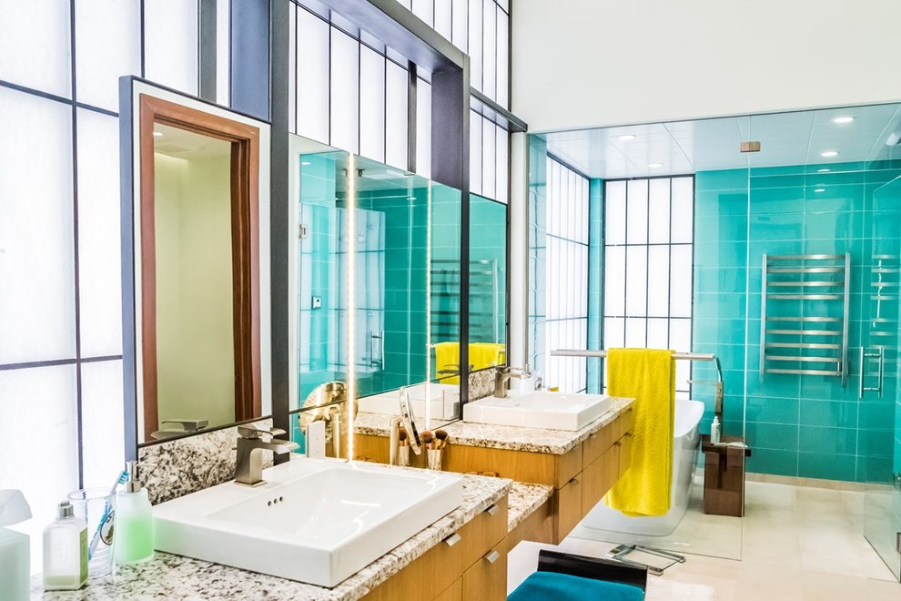 Freestanding bathtub - large mid-century modern master white tile and glass tile beige floor freestanding bathtub idea in Seattle with furniture-like cabinets, medium tone wood cabinets, blue walls, a drop-in sink and a hinged shower door