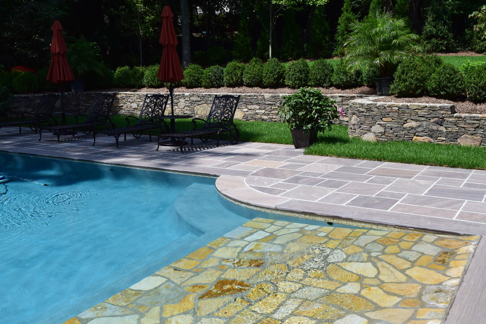 Inspiration for a mid-sized country backyard patio in New York with a water feature, natural stone pavers and no cover.