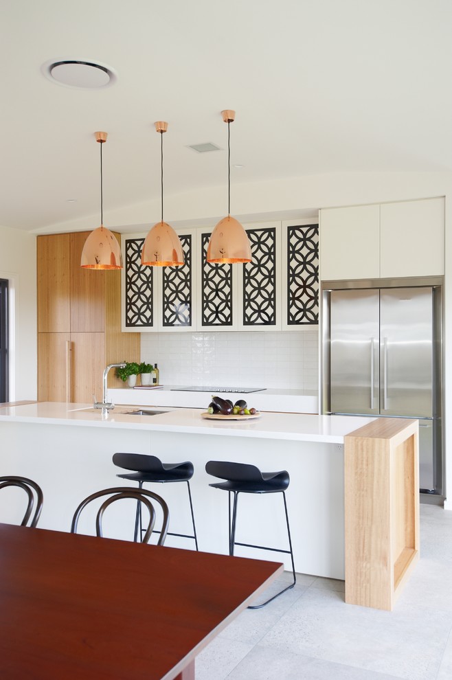 Design ideas for a contemporary galley open plan kitchen in Sydney with flat-panel cabinets, white cabinets, white splashback, stainless steel appliances, concrete floors, with island, grey floor and white benchtop.
