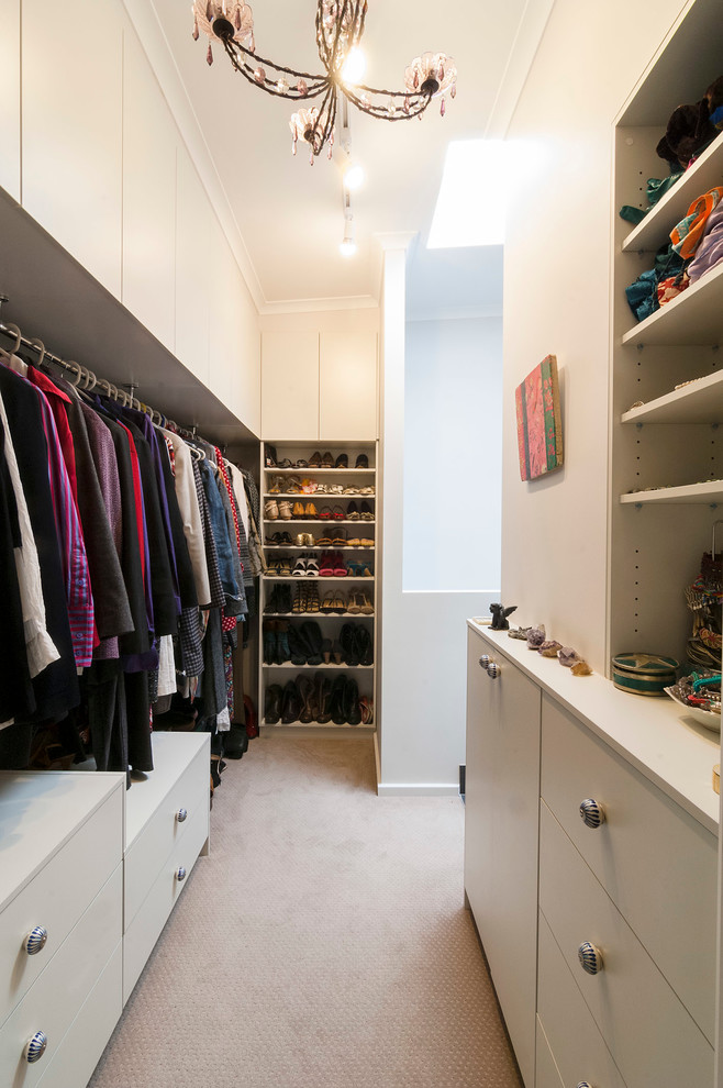 Large contemporary gender-neutral walk-in wardrobe in Canberra - Queanbeyan with carpet, flat-panel cabinets and white cabinets.