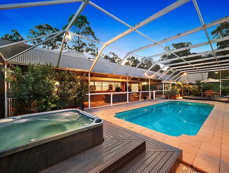Photo of a large contemporary pool in Brisbane with a pool house.