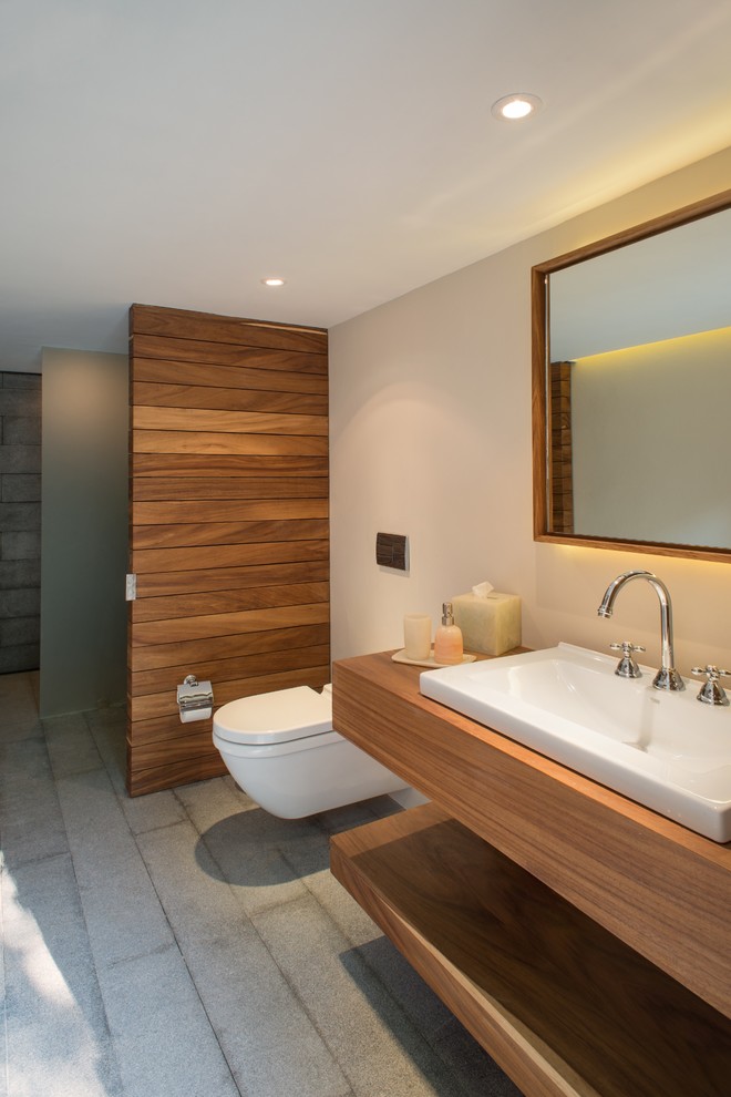 Design ideas for a mid-sized modern bathroom in Mexico City with a vessel sink, a wall-mount toilet, wood benchtops and brown benchtops.