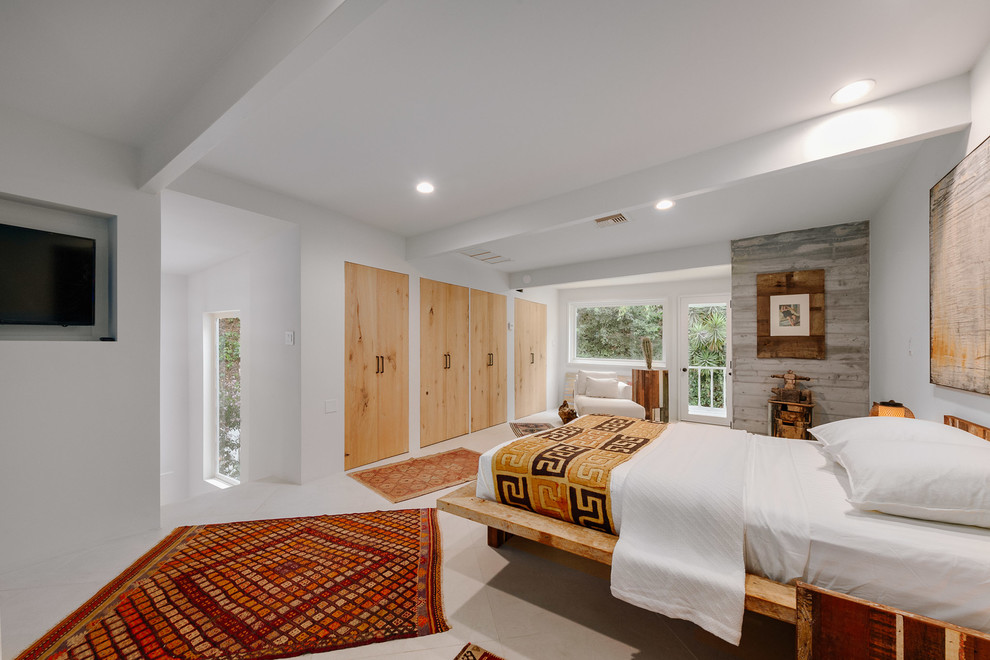 This is an example of an expansive midcentury master bedroom in Los Angeles with white walls and beige floor.