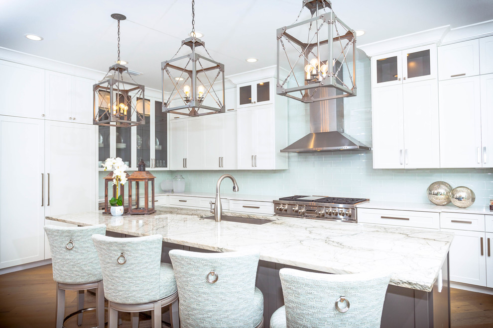 Inspiration for a mid-sized beach style kitchen in Miami with a drop-in sink, white cabinets, marble benchtops, blue splashback, stainless steel appliances, medium hardwood floors, with island and brown floor.