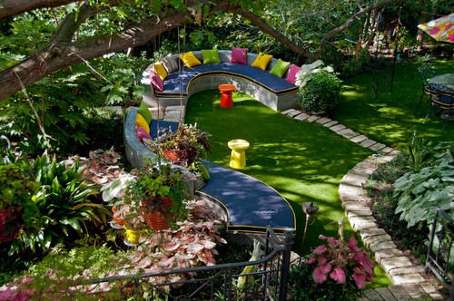 This fun yard has a long and quirky bench. The bright colors and wild curves make this bench stand out and catch the eye. This space comes across as a fun and playful yard that is young at heart.
