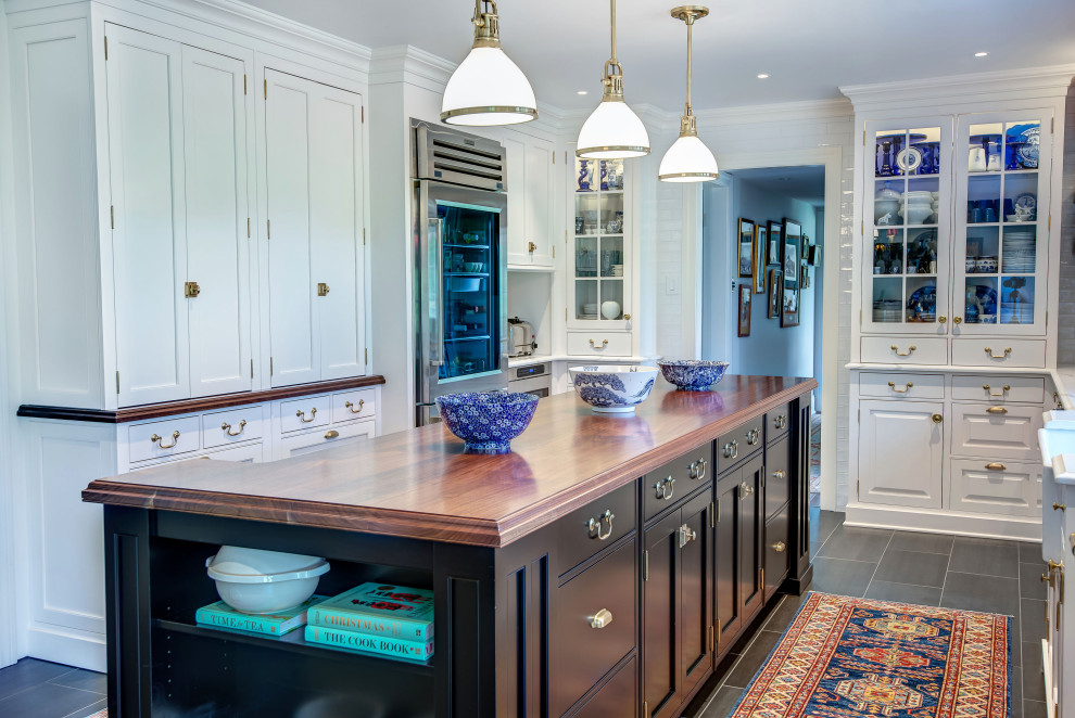 Inspiration for a large eclectic u-shaped eat-in kitchen in Philadelphia with beaded inset cabinets, white cabinets, wood benchtops, white splashback, with island and black floor.