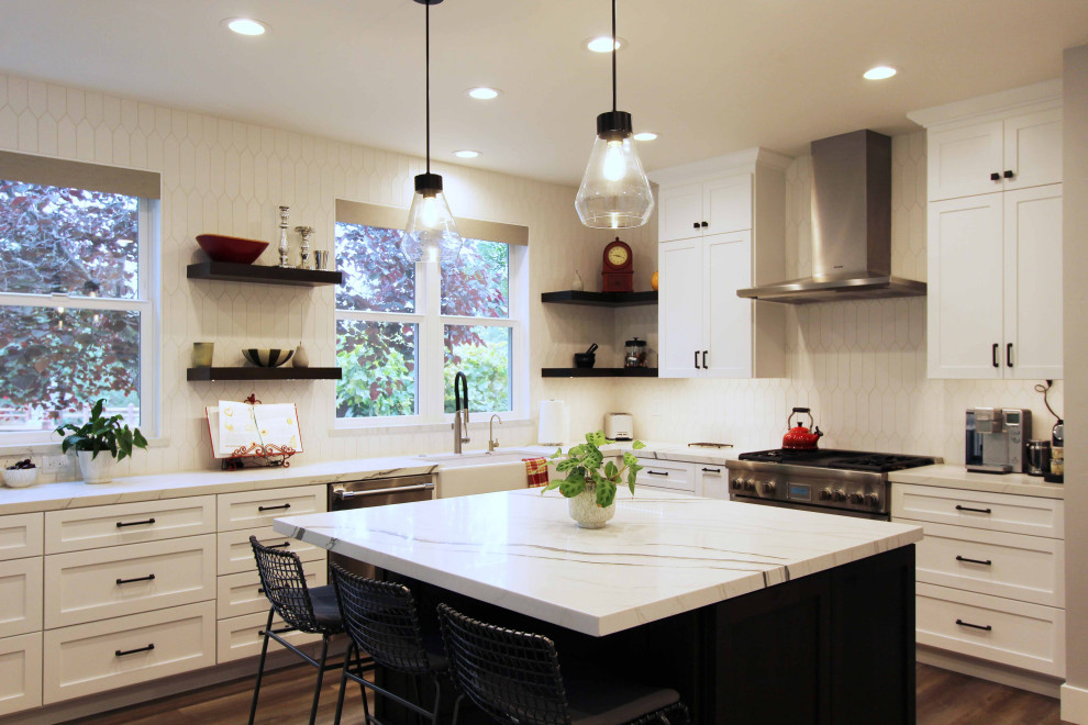 Open concept kitchen - large transitional l-shaped vinyl floor and brown floor open concept kitchen idea with a farmhouse sink, shaker cabinets, white cabinets, quartz countertops, white backsplash, ceramic backsplash, stainless steel appliances, an island and white countertops