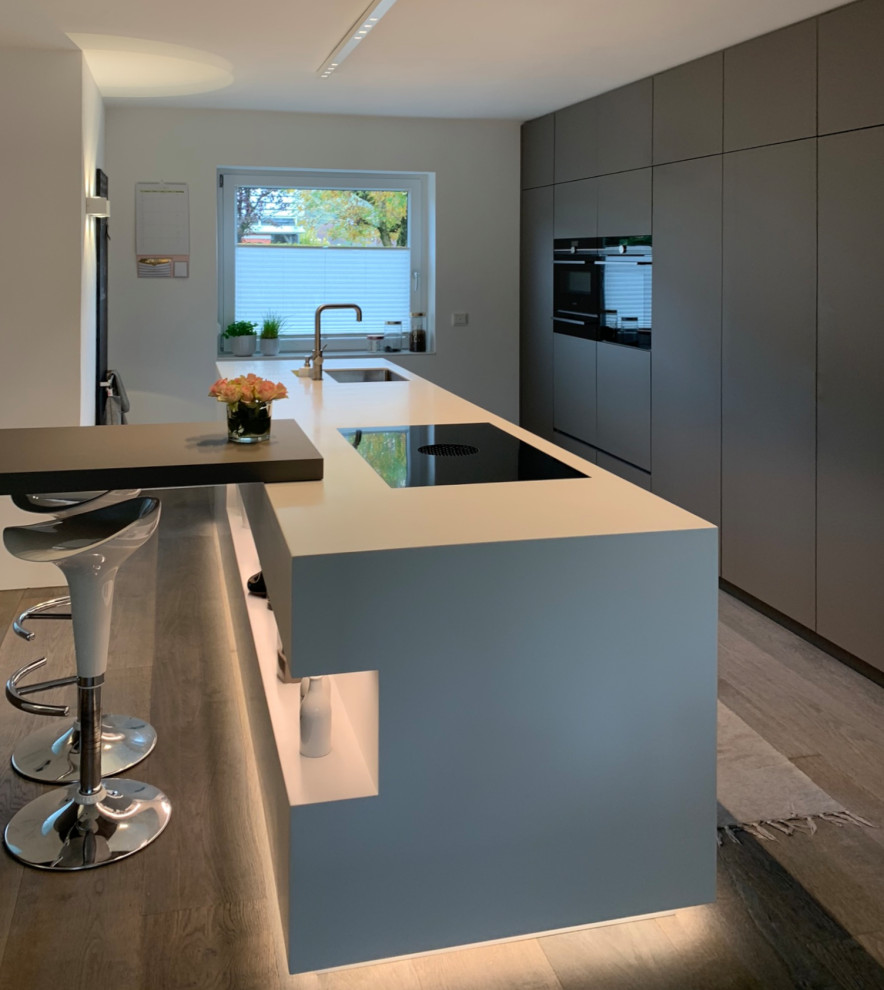Inspiration for a large contemporary open plan kitchen in Essen with an island, grey cabinets, composite countertops and painted wood flooring.