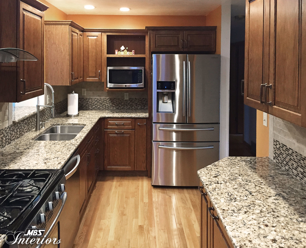 Inspiration for a small transitional light wood floor enclosed kitchen remodel with an undermount sink, medium tone wood cabinets, quartz countertops, gray backsplash, stone tile backsplash, stainless steel appliances and no island