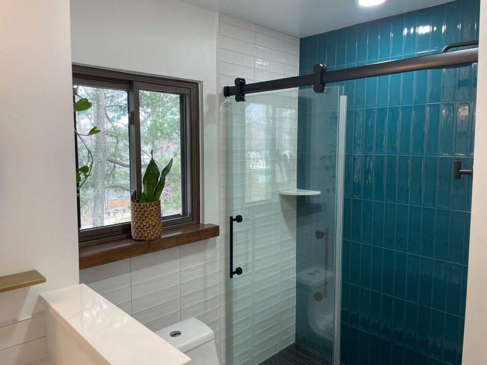 Photo of a mid-sized modern master bathroom in DC Metro with flat-panel cabinets, brown cabinets, an alcove shower, a one-piece toilet, white tile, porcelain tile, white walls, porcelain floors, an undermount sink, quartzite benchtops, grey floor, a sliding shower screen, white benchtops, a niche, a single vanity and a built-in vanity.