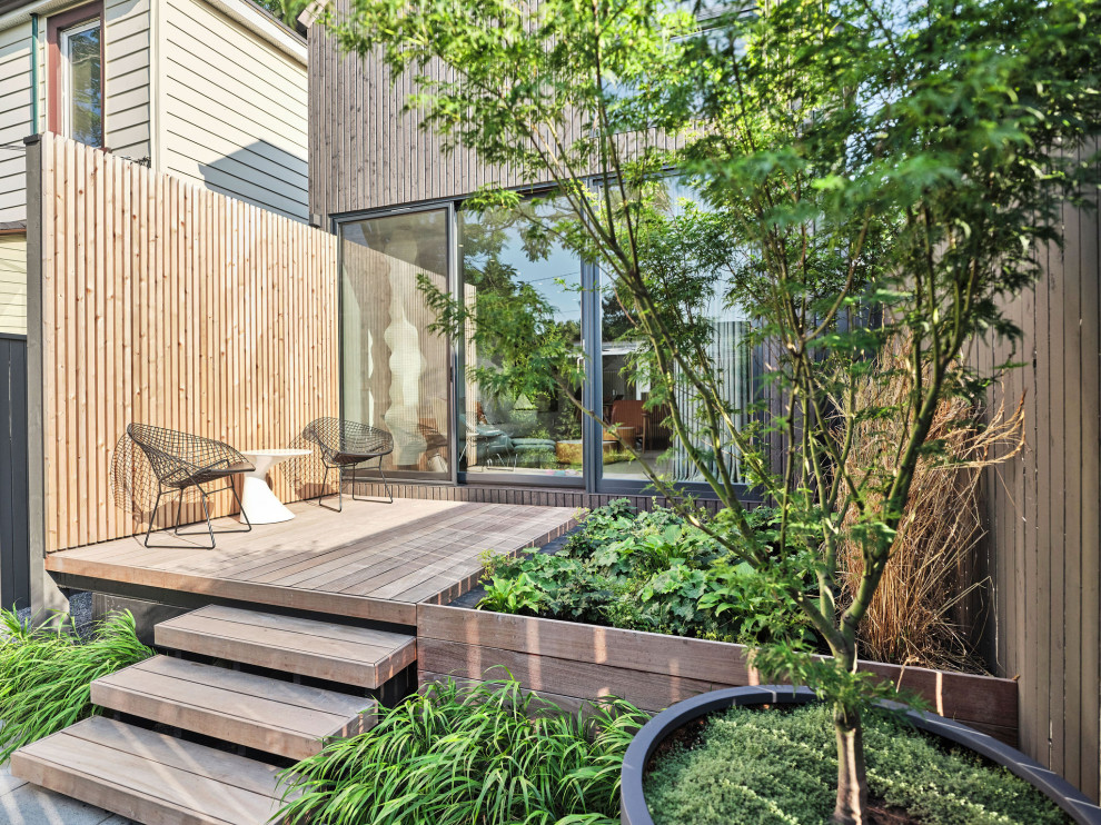 Photo of a small contemporary backyard partial sun formal garden for summer in Toronto with a garden path, concrete pavers and a wood fence.