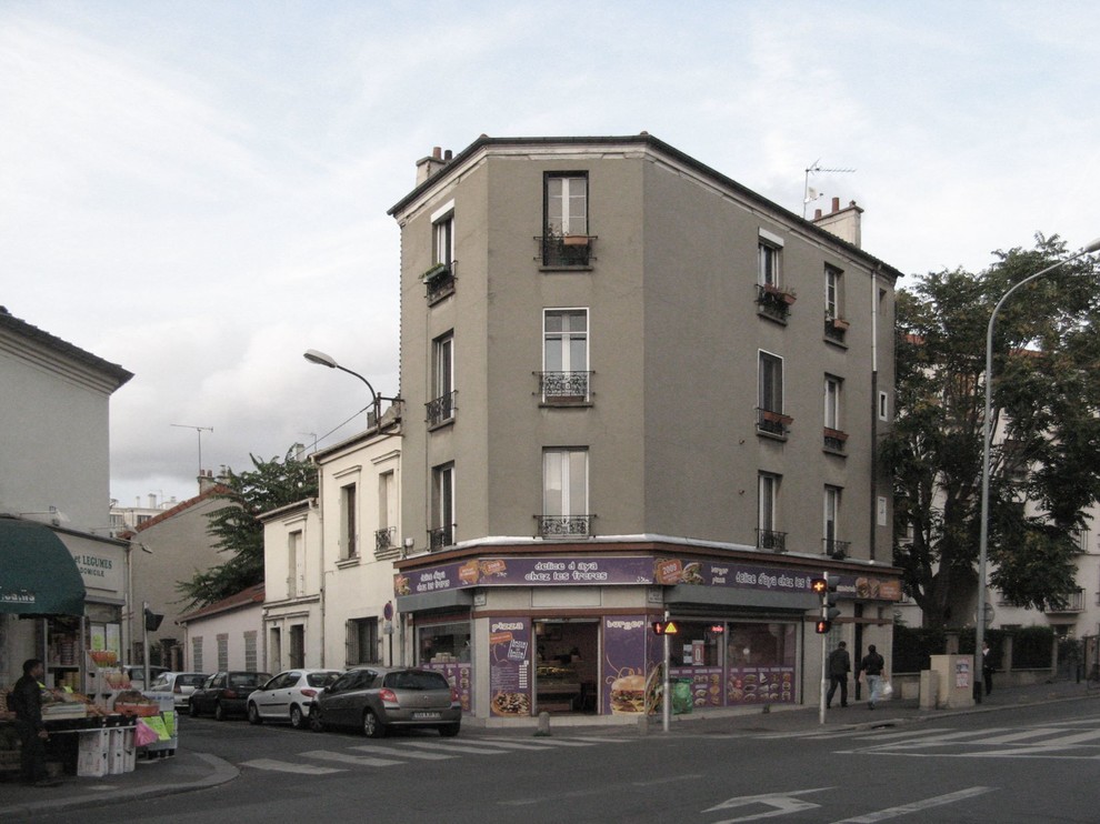 Photo of a mid-sized contemporary three-storey white apartment exterior in Paris with mixed siding, a flat roof and a mixed roof.
