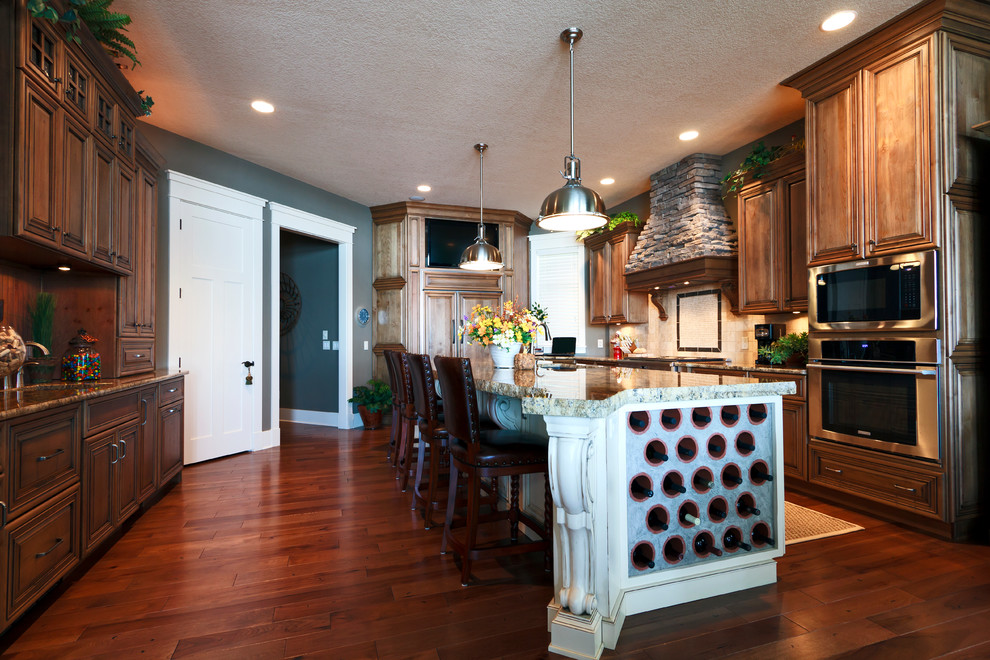 Inspiration for a transitional kitchen remodel with an undermount sink, raised-panel cabinets, medium tone wood cabinets, granite countertops, stone tile backsplash and paneled appliances