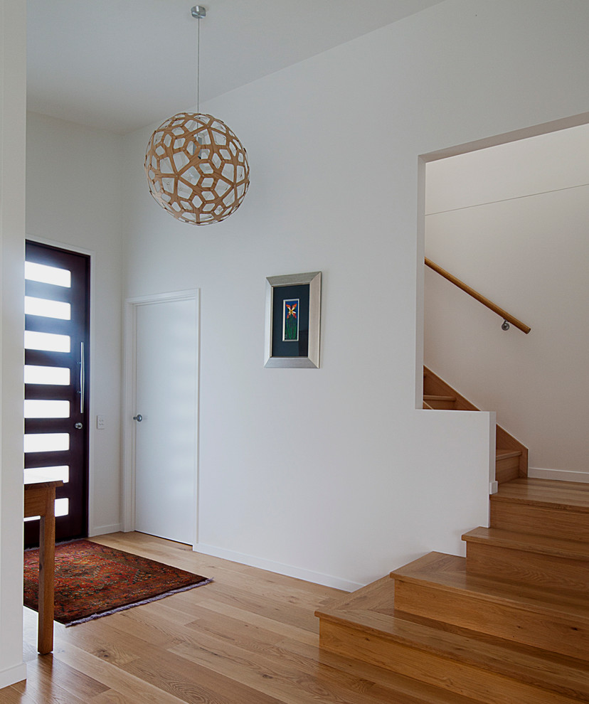 Mid-sized entry hall in Sunshine Coast with white walls, light hardwood floors, a pivot front door and a dark wood front door.