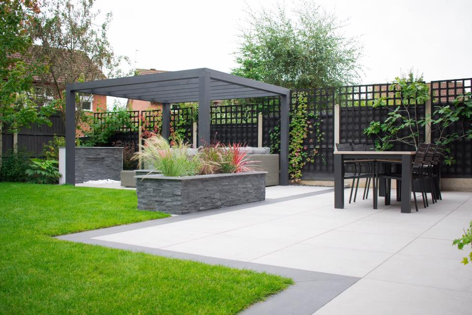 Photo of a mid-sized contemporary backyard formal garden for summer in West Midlands with with waterfall.