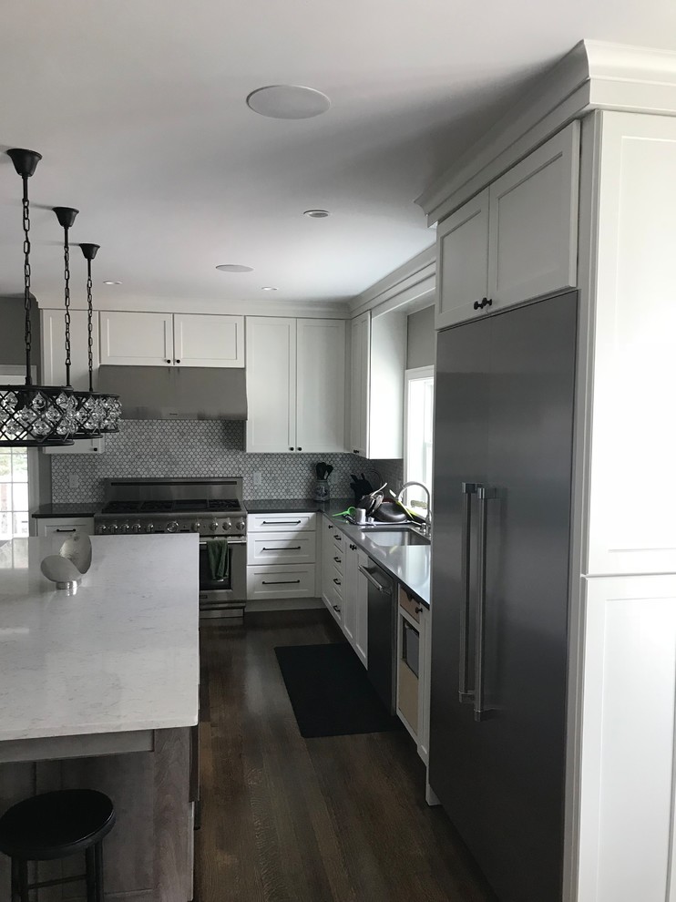 Enclosed kitchen - mid-sized transitional u-shaped dark wood floor and brown floor enclosed kitchen idea in Boston with an undermount sink, shaker cabinets, white cabinets, quartz countertops, gray backsplash, stainless steel appliances, an island and white countertops