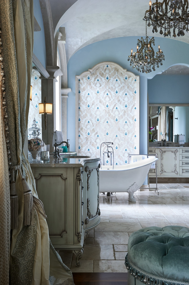 Inspiration for a large mediterranean master bathroom in Orlando with an undermount sink, furniture-like cabinets, white cabinets, marble benchtops, a claw-foot tub, an alcove shower, a one-piece toilet, white tile, porcelain tile, blue walls and marble floors.