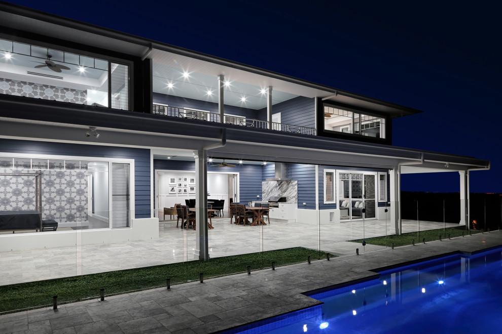 Expansive beach style backyard patio in Sunshine Coast with an outdoor kitchen, natural stone pavers and a roof extension.