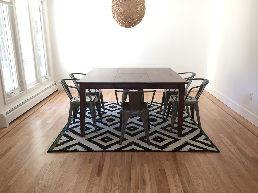 Example of a large transitional light wood floor and beige floor enclosed dining room design in Vancouver with white walls