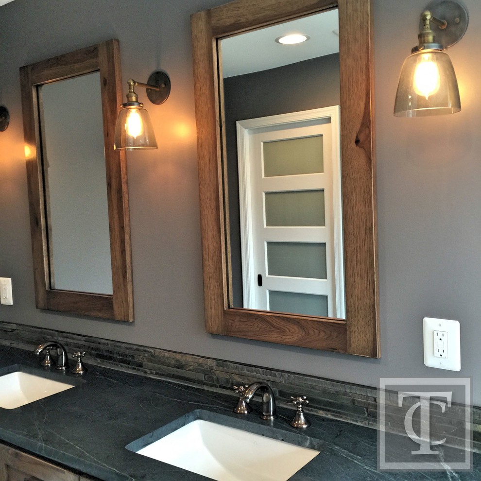 Photo of a mid-sized country master bathroom in Baltimore with an undermount sink, shaker cabinets, medium wood cabinets, soapstone benchtops, a freestanding tub, a double shower, a two-piece toilet, gray tile, stone tile, grey walls and porcelain floors.