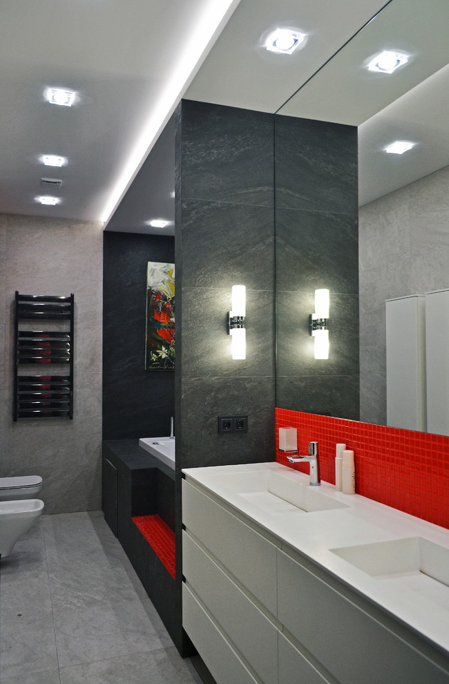 Inspiration for a mid-sized contemporary master bathroom in Moscow with flat-panel cabinets, white cabinets, an undermount tub, a bidet, black and white tile, porcelain tile, grey walls, porcelain floors, an integrated sink, solid surface benchtops, grey floor, white benchtops, an enclosed toilet, a double vanity, a floating vanity and recessed.