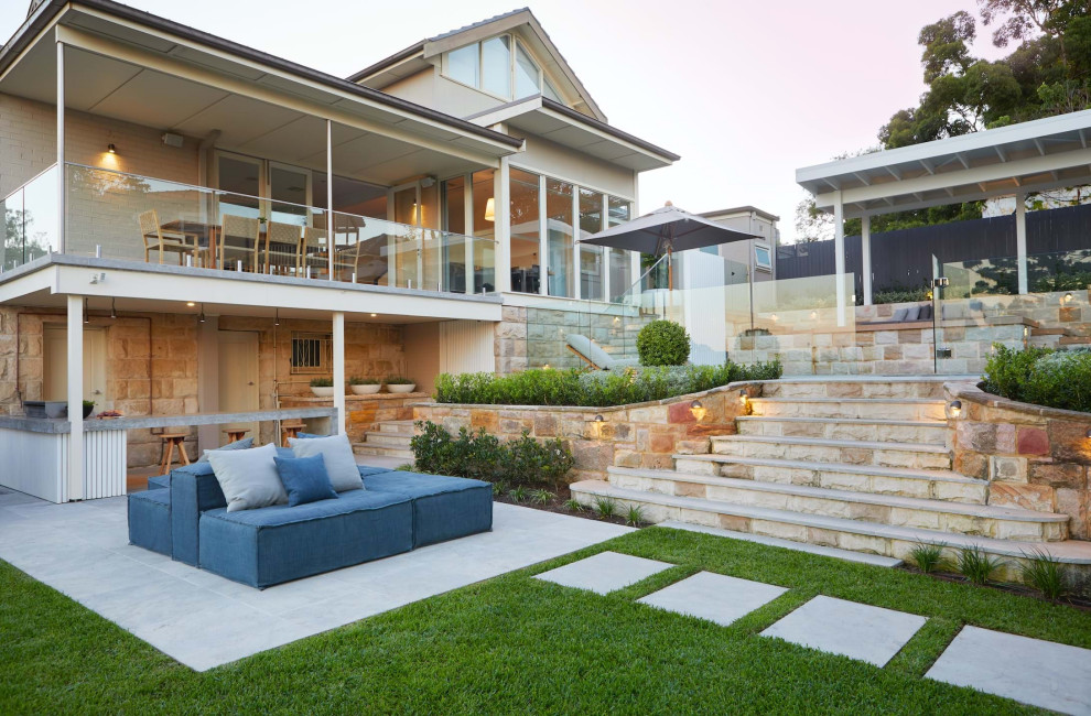 Photo of a large contemporary backyard patio in Sydney with an outdoor kitchen, concrete slab and a pergola.