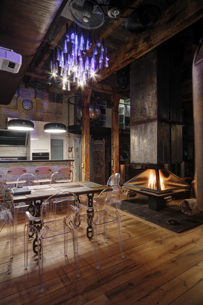 Design ideas for an industrial dining room in Moscow with a hanging fireplace.