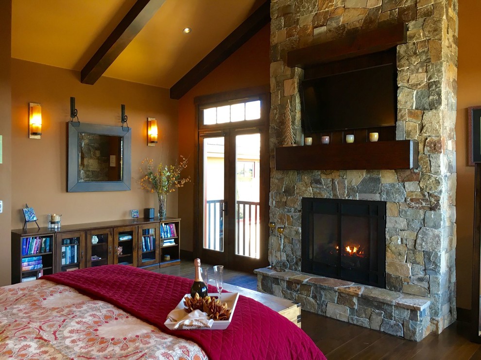 This is an example of a mid-sized transitional guest bedroom in Sacramento with beige walls, dark hardwood floors, no fireplace, a stone fireplace surround and brown floor.