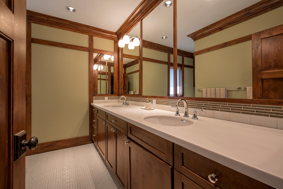 Photo of a mid-sized arts and crafts master bathroom in Omaha with an undermount sink, shaker cabinets, medium wood cabinets, quartzite benchtops, an alcove tub, an alcove shower, a two-piece toilet, beige tile, porcelain tile, green walls and porcelain floors.