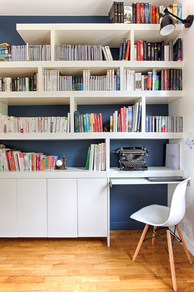 Aménagement d'un bureau scandinave de taille moyenne avec une bibliothèque ou un coin lecture, un mur bleu, parquet clair, aucune cheminée et un bureau indépendant.