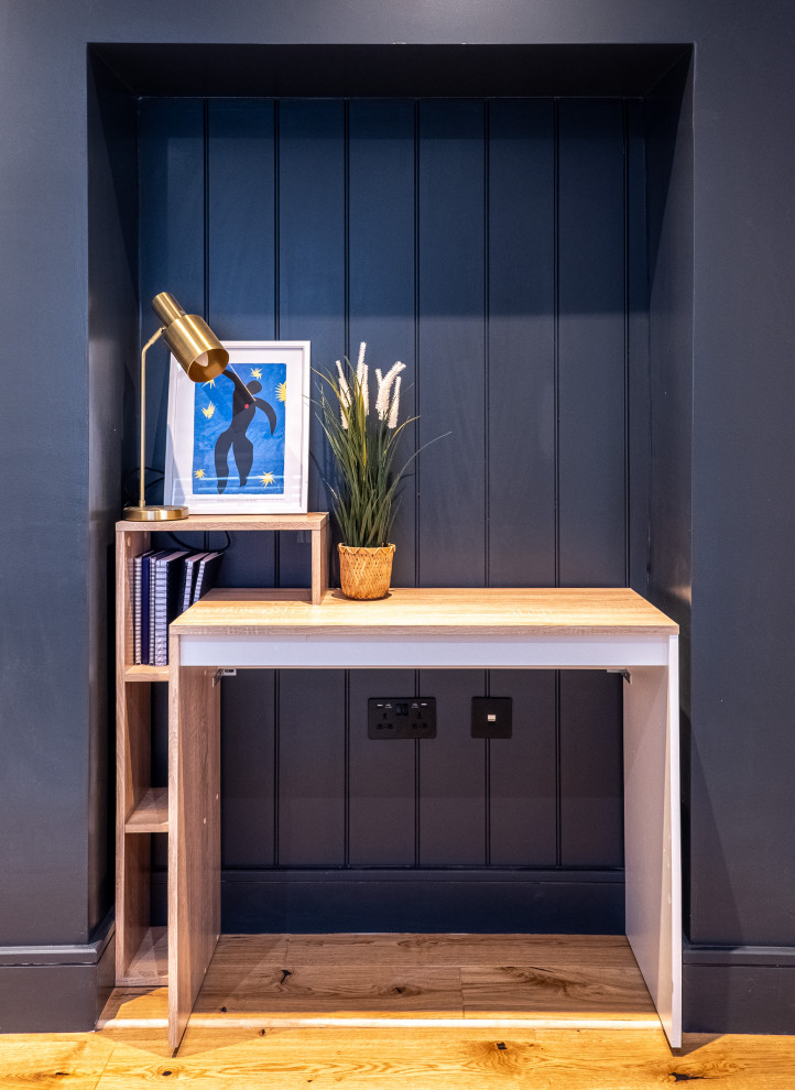 Small victorian home office in London with blue walls and a freestanding desk.