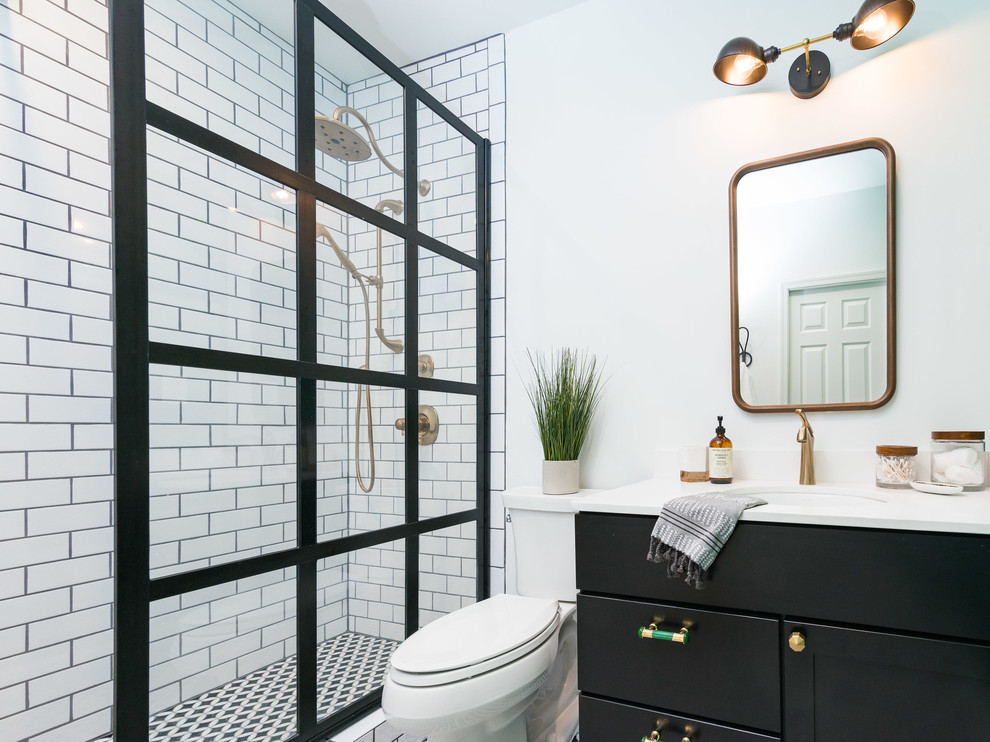 Photo of a mid-sized contemporary 3/4 bathroom in DC Metro with recessed-panel cabinets, black cabinets, a two-piece toilet, white tile, subway tile, white walls, an undermount sink, solid surface benchtops, multi-coloured floor, an open shower, white benchtops and an alcove shower.