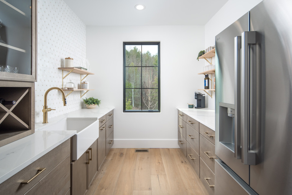 Kitchen - transitional medium tone wood floor kitchen idea with a farmhouse sink, quartzite countertops, marble backsplash and an island