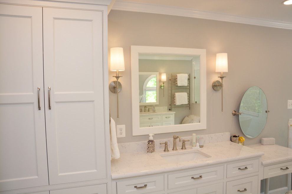 Photo of a large traditional master bathroom in Baltimore with recessed-panel cabinets, white cabinets, a freestanding tub, an alcove shower, a two-piece toilet, white tile, grey walls, an undermount sink, engineered quartz benchtops, grey floor, a hinged shower door, white benchtops, a shower seat, a double vanity and a freestanding vanity.