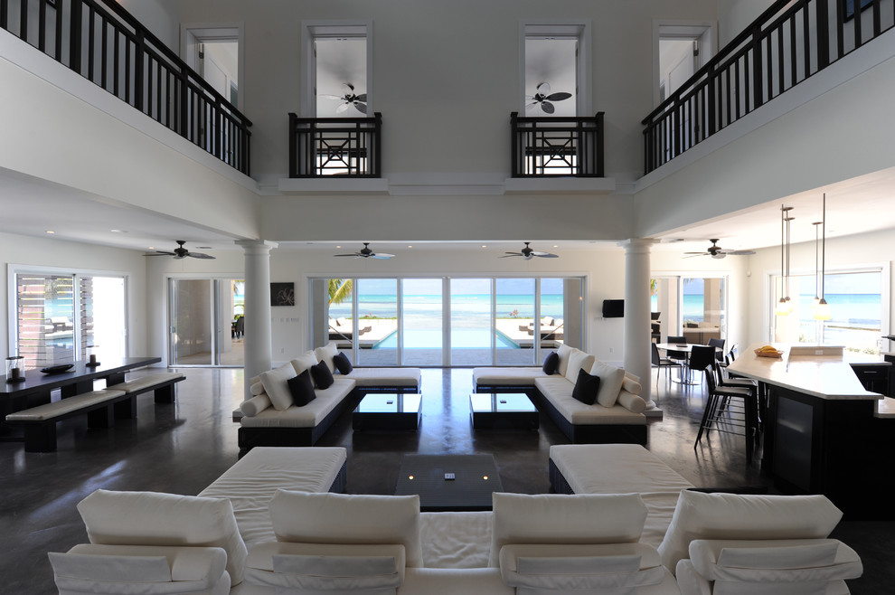 This is an example of a beach style living room in Other with concrete floors.