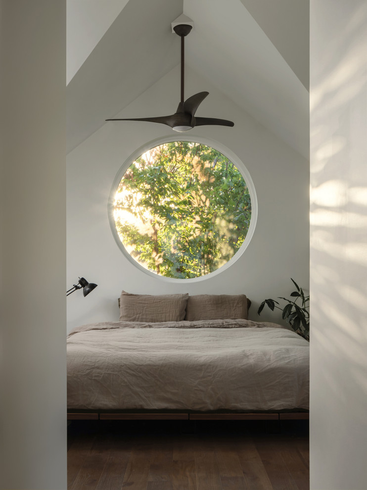 Kleines Modernes Hauptschlafzimmer mit weißer Wandfarbe, dunklem Holzboden, braunem Boden und gewölbter Decke in Austin