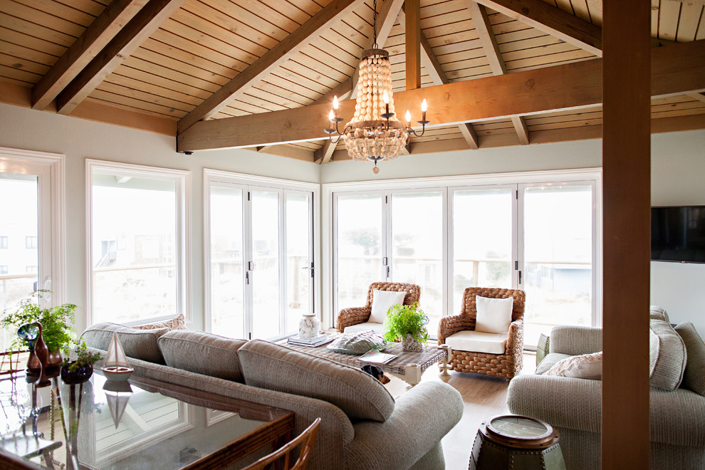 Inspiration for a mid-sized beach style open concept family room in San Francisco with a game room, blue walls, dark hardwood floors, a standard fireplace, a wood fireplace surround and a wall-mounted tv.